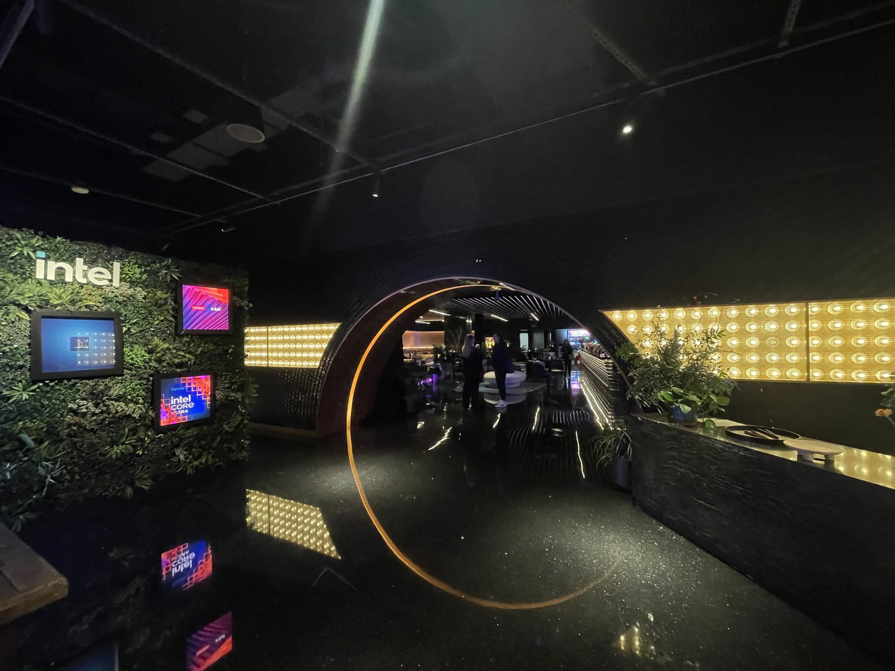 Entrance to Intel Oasis: a living green wall, Intel logo, and a warm circular arch into the lounge
